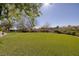 Expansive backyard featuring manicured grass and mature trees, providing a serene and private outdoor space at 9801 Orient Express Ct, Las Vegas, NV 89145