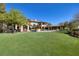 Expansive backyard with lush lawn, pool, and basketball court, perfect for outdoor entertaining and recreation at 9801 Orient Express Ct, Las Vegas, NV 89145