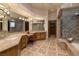 Spacious bathroom features marble countertops, beautiful tile floors, and a glass-enclosed shower, with a view into the walk-in closet at 9801 Orient Express Ct, Las Vegas, NV 89145