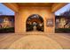 Elegant entrance featuring a stone archway, mosaic pavers, and beautiful landscaping at 9801 Orient Express Ct, Las Vegas, NV 89145