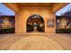 Grand entrance featuring intricate stonework, arched doorway, and well-manicured landscaping at 9801 Orient Express Ct, Las Vegas, NV 89145