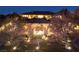 Elegant estate with manicured lawn and tasteful outdoor lighting, highlighting the home's architecture and lush landscaping at 9801 Orient Express Ct, Las Vegas, NV 89145