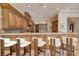 Spacious kitchen bar with wooden cabinetry, granite counters, and four stools for seating at 9801 Orient Express Ct, Las Vegas, NV 89145