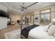 Spacious main bedroom with a stone fireplace, a four poster bed, and multiple windows at 9801 Orient Express Ct, Las Vegas, NV 89145