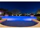 Backyard view of a sparkling pool surrounded by mature trees at dusk at 9801 Orient Express Ct, Las Vegas, NV 89145