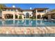 A stunning swimming pool with a basketball hoop sits in front of a grand two-story home with ample windows and balconies at 9801 Orient Express Ct, Las Vegas, NV 89145