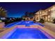 Beautiful backyard with a sparkling pool and spa at night at 9801 Orient Express Ct, Las Vegas, NV 89145