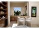 A cozy wet bar area featuring custom cabinetry, a sleek countertop, and a scenic outdoor view at 9801 Orient Express Ct, Las Vegas, NV 89145