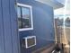 A view of the side exterior showing blue wood siding and an AC unit at 11 Magnesium St, Henderson, NV 89015