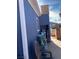 An exterior view of the side of the home showing blue wood siding, a window, boxes, and a chair at 11 Magnesium St, Henderson, NV 89015
