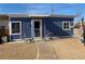 Charming single-story home with blue wood siding, trimmed windows, and cozy chairs on the front walkway at 11 Magnesium St, Henderson, NV 89015