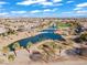 Scenic aerial view of the community with a pond, lush landscaping, and a distant city skyline at 11321 Golden Chestnut Pl, Las Vegas, NV 89135