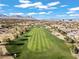 Aerial view of the manicured golf course, surrounded by homes and mountain views at 11321 Golden Chestnut Pl, Las Vegas, NV 89135