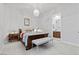 Bright bedroom featuring a chandelier, a cozy bed with a cushioned bench, and access to the en-suite bathroom at 11321 Golden Chestnut Pl, Las Vegas, NV 89135