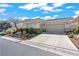 Beautifully landscaped front yard and driveway leading to the home's two-car garage at 11321 Golden Chestnut Pl, Las Vegas, NV 89135