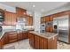 Elegant kitchen with stainless appliances, island, wood cabinetry and granite countertops at 11321 Golden Chestnut Pl, Las Vegas, NV 89135