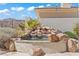 Backyard rock waterfall flows into a cozy pool, surrounded by lush desert landscaping, offering a tranquil retreat at 11321 Golden Chestnut Pl, Las Vegas, NV 89135