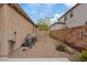 Low-maintenance backyard with gravel landscaping, mature tree, and block wall fence at 1269 Olivia Pkwy, Henderson, NV 89011