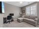 Well-lit bedroom featuring a gray sofa, desk and chair, and plantation shutters at 1269 Olivia Pkwy, Henderson, NV 89011