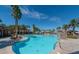 Expansive swimming pool features clear blue water, poolside stone features, and lush palm trees at 1269 Olivia Pkwy, Henderson, NV 89011