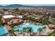 Aerial view of luxurious community pool with palm trees, sun loungers, and surrounding community buildings at 1269 Olivia Pkwy, Henderson, NV 89011