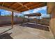 View of a concrete backyard with a covered patio featuring brick accents and wooden supports at 1413 Culley St, Las Vegas, NV 89110