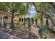 Close-up of a well-manicured front yard filled with trees, shrubs, and low-water plants at 1413 Culley St, Las Vegas, NV 89110