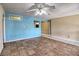 Open living room with a ceiling fan, blue accent wall and access to multiple rooms at 1413 Culley St, Las Vegas, NV 89110
