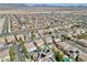 Expansive aerial view of a residential community featuring beige homes, many with solar panels, pools, and desert landscaping at 1609 Danielle Rebecca Ave, North Las Vegas, NV 89086