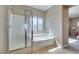 This bathroom features a separate shower and tub with natural light streaming through the window at 1609 Danielle Rebecca Ave, North Las Vegas, NV 89086