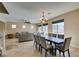 Open-concept dining area with a large table, pendant lighting, and views into the living room at 1609 Danielle Rebecca Ave, North Las Vegas, NV 89086