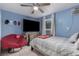 Bright bedroom with blue walls, featuring a comfortable bed, television, and seating area at 1924 S 6Th St, Las Vegas, NV 89104