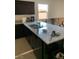 Granite countertops, dark cabinets, and a stainless steel sink are featured in this cozy kitchen at 1926 Neoga St, Las Vegas, NV 89115