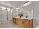 Bright bathroom featuring a double sink vanity, a large mirror, and a glass-enclosed shower at 2572 Favorable Pointe Ct, Henderson, NV 89052