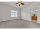 Empty bedroom with large window, ceiling fan and attached bathroom at 2572 Favorable Pointe Ct, Henderson, NV 89052