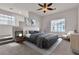 Bright bedroom with a ceiling fan, a gray bed, and a staircase feature at 2572 Favorable Pointe Ct, Henderson, NV 89052