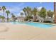 Spacious community pool surrounded by palm trees and lounge chairs, creating a tropical and inviting atmosphere at 2572 Favorable Pointe Ct, Henderson, NV 89052