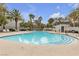 Large community pool with ample seating and palm trees, providing a refreshing and resort-like experience at 2572 Favorable Pointe Ct, Henderson, NV 89052