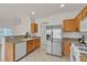 Bright kitchen featuring stainless steel appliances, wooden cabinets, and granite countertops at 2572 Favorable Pointe Ct, Henderson, NV 89052