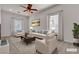 Bright, staged living room features plush seating, neutral tones and ceiling fan at 2572 Favorable Pointe Ct, Henderson, NV 89052