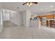 Open-concept living room and kitchen with tile flooring, staircase, and natural light at 2572 Favorable Pointe Ct, Henderson, NV 89052