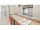 Well-lit bar area featuring granite countertops, cabinetry, and a view into a spacious living room at 2694 Caumsett Ct, Las Vegas, NV 89117