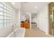 Bright bathroom with bathtub, windows, and wooden cabinets at 2694 Caumsett Ct, Las Vegas, NV 89117