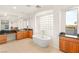 Bright bathroom features a soaking tub, natural light, and wood cabinets at 2694 Caumsett Ct, Las Vegas, NV 89117