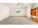 Large bedroom with neutral colored carpet, built in wood shelving and storage, and a window with a view at 2694 Caumsett Ct, Las Vegas, NV 89117