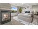 Bedroom featuring a fireplace, large window, and king bed with modern bedding and a plant at 2694 Caumsett Ct, Las Vegas, NV 89117