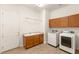 Neat laundry room featuring a sink with wooden cabinets and a new washer and dryer set at 2694 Caumsett Ct, Las Vegas, NV 89117