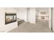 Living room featuring a modern fireplace, gray carpet, and doorway to lofted area with wood and wrought iron railing at 2694 Caumsett Ct, Las Vegas, NV 89117