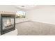 Spacious room featuring a modern fireplace, light gray carpet, and a large window with a view of palm trees at 2694 Caumsett Ct, Las Vegas, NV 89117