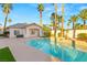 Inviting backyard pool and spa complemented by lush palm trees and a well-manicured outdoor space at 2694 Caumsett Ct, Las Vegas, NV 89117